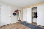 Welcoming entrance of a stylish apartment featuring hardwood flooring and spacious walk-in closets.