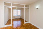 Spacious apartment living area with hardwood floors and large windows in Washington, DC.