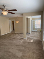 Interior view of a spacious apartment in The Park at Catania with natural light and carpeted flooring.