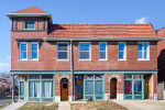 Exterior view of a two-bedroom apartment building featuring brick facade and decorative roofing.