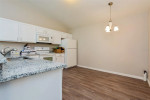 Modern kitchen area featuring granite countertops, white cabinets, and stainless appliances in a cozy villa.