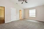 Spacious primary bedroom in a well-maintained patio villa in The Villages, FL, featuring plush carpeting and natural light