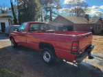1998 Dodge Ram 1500 V6 pickup truck with 143,698 miles parked outside a home.