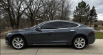 2020 Tesla Model S in Midnight Metallic Gray, featuring tinted windows and sporty wheels.
