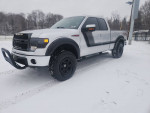 Lifted 2014 Ford F-150 FX4 in snow with aftermarket rims and tires, showcasing a robust design and premium features.