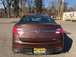 Rear view of a 2015 Ford Taurus Police Package, brown color with AWD and no visible damage.