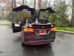 Fully loaded 2016 Tesla Model X with motorized spoiler and open doors parked in a residential area.
