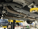 Undercarriage view of a Ford Mustang GT showcasing its exhaust system and suspension components.