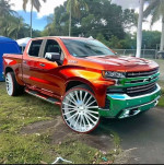 2024 Chevrolet Silverado 3500HD High Country in vibrant orange and chrome with oversized wheels, available for sale or rental.
