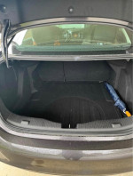 Trunk space of a 2014 Chevrolet Cruze 1LT with an umbrella and clean carpeting.