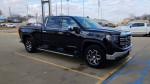 2023 GMC Sierra 1500 black truck parked, available for sale, featuring modern design and spacious cabin.
