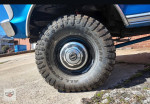 Close-up of a rugged tire on a 1991 Ford F-250 XL, showcasing its strong tread and chrome wheel.