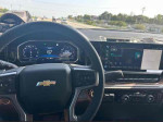 Interior view of a 2024 Chevrolet Silverado 2500HD Work Truck dashboard while driving, showing speed and infotainment system.