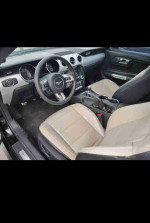 Interior of a 2015 Ford Mustang EcoBoost Premium with beige leather seats and modern dashboard features.