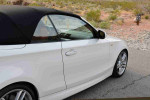 2013 BMW 135i Convertible in white, showcasing sleek design and sporty aesthetics, parked in a natural setting.