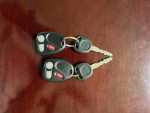 Two Chevrolet keys on a wooden surface, associated with a 2003 Chevrolet S-10 LS ZR2 for sale.