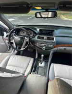 Interior view of a well-maintained 2012 Honda Accord EX-L V-6 with gray leather seats and modern dashboard features.