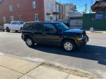2015 Jeep Patriot Sport parked on the street, showcasing its clean exterior in a residential area.