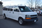 White 2016 Chevrolet Express 3500 Cargo Van with 74,000 miles parked outside a dealership.