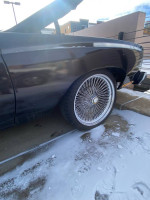 Side view of a classic 1977 Monte Carlo with wire wheels, showcasing its polished exterior and iconic design.