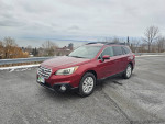 2015 Subaru Outback in red color parked with a scenic view, featuring new winter tires and clean interior.