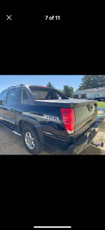 2003 Chevrolet Avalanche truck with clean interior, showing slight rust on back doors.