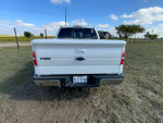 Rear view of a 2013 Ford F150 Lariat 4X4 in excellent condition, parked in a grassy area.