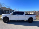 2020 Ford F150 Lariat in white with black wheels, showcasing modern design and features.
