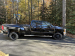 2009 Chevrolet Silverado 1500 Work Truck 4WD parked in a wooded area with basketball hoop.