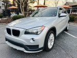2015 BMW X1 xDrive28i AWD in silver parked, showcasing clean exterior and sleek design.