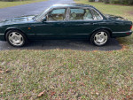 1996 Jaguar XJR in beautiful condition parked on grass, showcasing its sleek design and polished wheels.