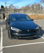 2023 Tesla X in mint condition parked with sleek black finish and premium carbon fiber rims.