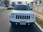 Front view of a well-maintained 2014 Jeep Patriot SUV with 139,000 miles, parked on a residential street.