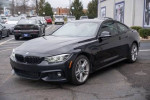2020 BMW 430i xDrive Coupe in Black Sapphire Metallic parked, showcasing its sleek design and luxury features.