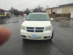 White 2010 Dodge Grand Caravan with 156k miles parked in a lot, featuring clean exterior and electric doors.