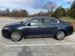 2014 Lincoln MKS in blue, good condition, parked in a lot, showcasing its sleek design and new tires.