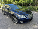 2010 Lexus LS460 AWD with 124,000 miles parked on a scenic road, showcasing its smooth design and shine.