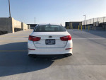 Rear view of a white 2015 Kia Optima parked, showcasing its clean design and new tires.