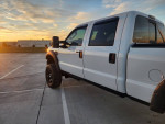 2009 Ford F250 Superduty Lariat Diesel with custom wheels and lift kit parked at sunset