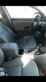 Interior view of a 2010 Chevrolet Impala with gray leather seats and wood grain console.