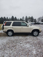 2001 Honda CR-V SE AWD in silver parked on gravel, featuring alloy wheels and a rugged design.