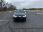 Front view of a 2010 Ford Focus SES in excellent condition parked in an empty lot, showcasing its sleek black exterior.
