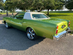 1976 Chevy Custom Cloud green car with chrome wheels parked in a scenic area, showcasing its classic design.