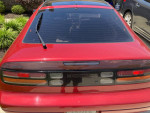 Rear view of a 1990 Nissan 300ZX in great condition, showcasing red color and sleek design features.