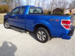 2014 Ford F150 STX Extended cab 2WD in blue with matching tires parked on gravel