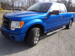 2014 Ford F150 STX extended cab in blue color parked on gravel, showcasing clean design and good tires.
