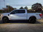 2023 Ford F150 FX4 Hybrid POWERBOOST with 12K miles, black wheels, and full technology package in a parking lot.