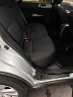 Interior view of a 2011 Subaru Forester 2.5X with spacious back seats and clean upholstery.