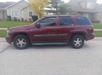 2004 Chevrolet TrailBlazer 4x4 in maroon color, parked on a residential street with no rust