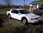 1994 Mercury Cougar V8 in excellent condition, low mileage, parked on grassy area outside a house.